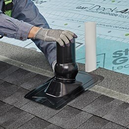 GAF contractor lining up the Master Flow Pivot roof boot over plumbing pipe.